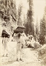 Mountain mail runners. Mail runners balance large sacks of letters on their heads as they travel