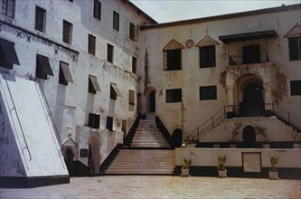 Courtyard of Elmina Castle. The paint-peeled walls of a sunny courtyard inside the walls of Elmina