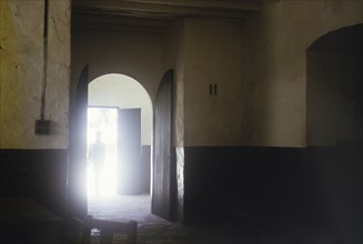 Interior of slave market, Elmina Castle. A sunlit doorway leads into the dark interior of the old