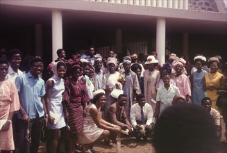 Nigerian wedding. A group of smiling wedding guests, mostly dressed in European-style clothing,