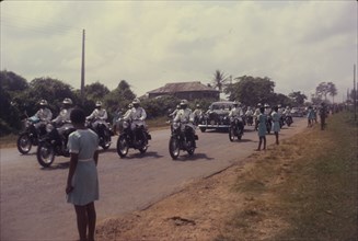 General Gowon approaches. Schoolgirls watch from a roadside as General Gowon, Head of the Federal