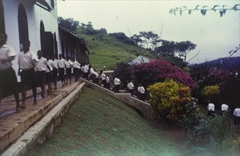 Church of Nigeria schoolboys. Uniformed boys file up steps and across a terrace on their way to