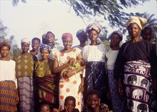 Midwife Olayinka with maternity patients. A qualified midwife identified as 'Olayinka', stands