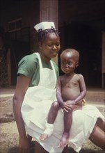 Midwife with a malnourished child. Portrait of a uniformed midwife from a Church of Nigeria