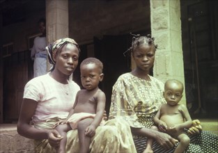Patients at a Church of Nigeria Hospital. Portrait of two Nigerian women, seated outside a Church