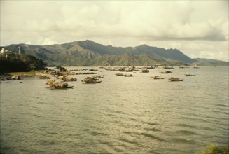 Fishing boats off Tai Po. Mountains form a backdrop to a fleet of Chinese sampans that bob up and