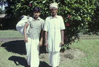 A 'dhobi' and his assistant. Outdoors portrait of a 'dhobi' (laundryman) and his assistant carrying