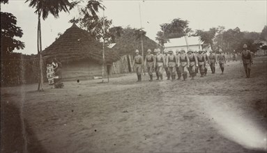 European soldiers in East Africa. A group of uniformed European soldiers wearing solatopis march in