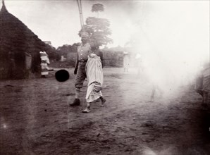 Woman escorted to execution. An African woman is escorted across a compound by an African soldier