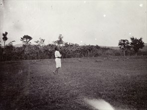 Playing football. An African boy in a field is captioned as 'playing football'. Uganda, 1906.