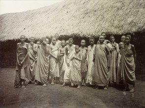 Group portrait, Uganda, 1906. About twenty men, women and children pose for their photograph in