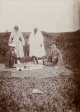Picnic lunch, Morocco. Two European men enjoy a picnic on a blanket in an open field: their