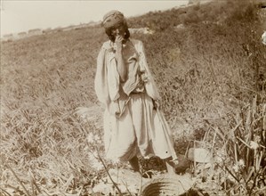 Woman fieldworker, Morocco. Outdoors portrait of a young woman in a field with a basket. Morocco,