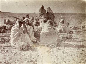 Relaxing after a day's work. A group of Arabic men relax, wrapped in their long white robes, after