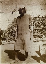Labourer in Safi, Morocco. Outdoors portrait of a barefoot labourer in ragged clothing, standing in