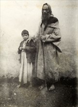 Jewish beggar, Safi. A barefoot Jewish beggar of gaunt appearance rests his hand on a young boy's