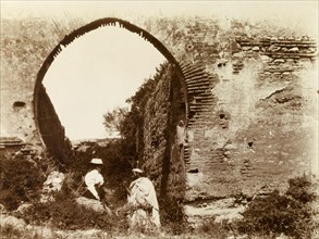 Islamic-style arch, Morocco. A Moroccan man talks to a Europan woman beneath an Islamic-style brick