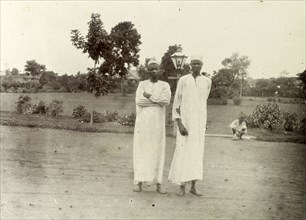 Domestic servants, Kenya. Two African men dressed in long white robes are pictured against the