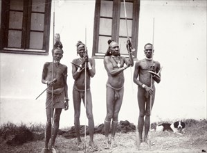 Four Turkana warriors. Four nearly naked Turkana men wearing headdresses pose for the camera,