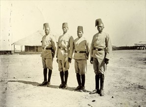 Four askaris of the King's African Rifles. Four uniformed askaris (soldiers) wearing fez hats line