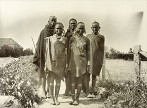 Young Kikuyu men and women. Informal group portrait of two young Kikuyu women and three men.