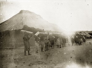 Porters in German East Africa. A line of African porters carry crates of goods to the Congo on
