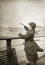 Charles Trotter on a pier. Charles Trotter, aged about 12 years old, throws pebbles into the sea