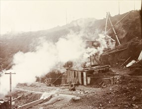 Pumps at the Premier Diamond Mine. Makeshift huts, possibly pump houses, are enveloped in steam at