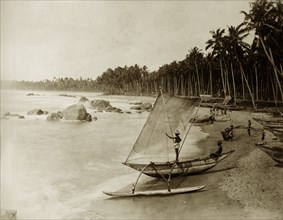 Fishing boat and crew, Ceylon. Groups of fishermen survey the sea, their boats moored on the beach.