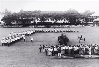 King George VI's birthday parade, Guyana. Uniformed police officers, some mounted on horseback,