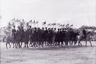 March past at the wall'. A troop of mounted police officers trot in line with flags at the Eve