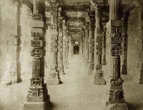 Carved pillars at the Quwwat-ul-Islam Mosque. Intricately carved stone pillars line a passageway at