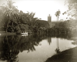 Afloat in the Eden Gardens. A couple in a rowing boat glide across the still waters of a pool in