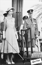 Queen Elizabeth II ready to perform an accolade, 1954. Queen Elizabeth II stands on an outdoor