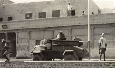 Armoured vehicle patrolling Aden during riots, 1947.. A light armoured vehicle is driven along a