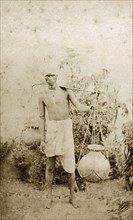 Indian water carrier. Portrait of an Indian man transporting water in clay pots tied to either end