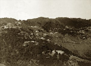 Mussoorie hill station, India. Houses cling to the forested mountainside at Mussoorie hill station,