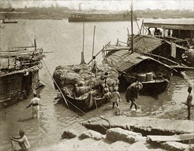 Loading jute at Serajgunge. Indian workers load bales of jute onto a cargo boat at the riverside