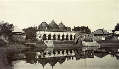 Waterside temple, India. Steps lead down into a pool of water from a temple decorated with arches