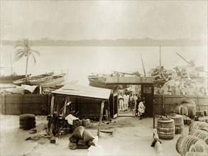 Jetty at Badagry. Cargo boats wait at a riverside jetty belonging to the African Oil Nuts Company,