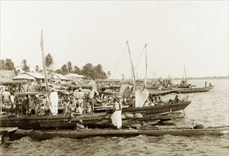Market day in Badagry. People aboard fishing boats crowd the waterside at Badagry harbour on market