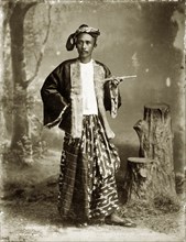 Portrait of a Burmese gentleman. A posed studio portrait of a finely-dressed Burmese gentleman. His