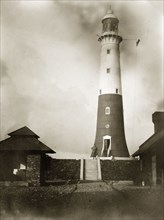 Beacon Island lighthouse. A 'G.E.W. inspector' poses on steps beside the Beacon Island lighthouse.