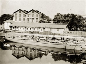 A Bombay dockyard. Long barges moored in a dockyard. Bombay (Mumbai), India, circa 1900. Mumbai,