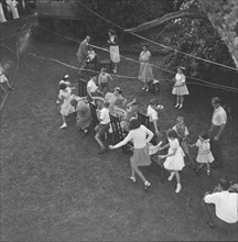 Musical chairs. Overhead view of children at the Button's party playing musical chairs in a garden.