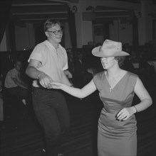 Couple at a Jazz Ball. A young couple dance together at a Jazz Ball. The woman wears a trilby hat,