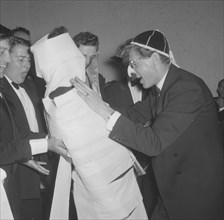 The Mogambo mummy. Members of a rugby team dressed in tuxedos fool around at the Mogambo Club. One