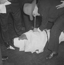 Rugby team antics. Members of a rugby team dressed in tuxedos fool around at the Mogambo Club. One