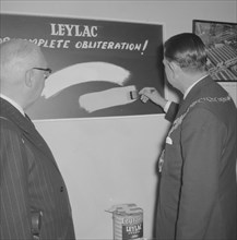 Leyland Paint Factory. A Mayor, dressed in a suit and ceremonial chain, tests a brushful of Leylac