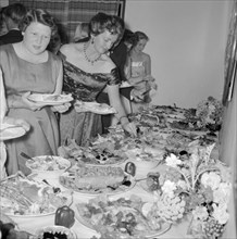 Buffet supper. Formally dressed guests at the Orme-Smith 21st birthday party queue up to help